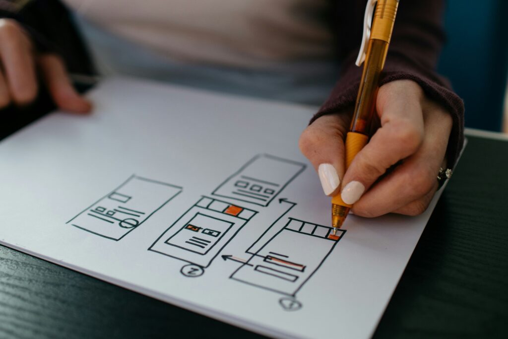 Konzentration auf das Wesentliche – Hände zeichnen Wireframes für strukturiertes und benutzerfreundliches Webdesign